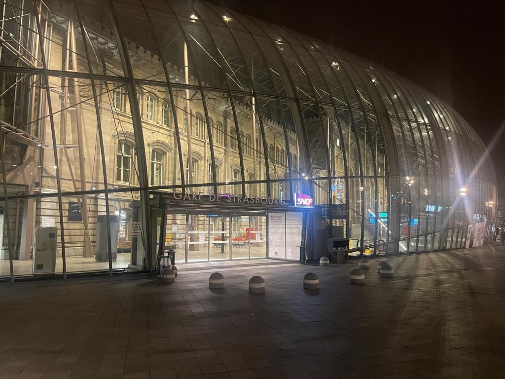 Vue nocturne de la Gare de Strasbourg : verrière en verre, façade historique illuminée et entrée principale SNCF — taxi à la gare et transfert avec Central Taxi 67.